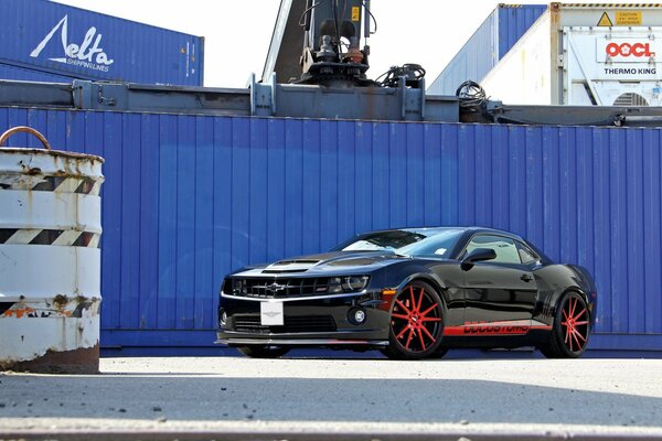 Chevrolet black car on a fence background