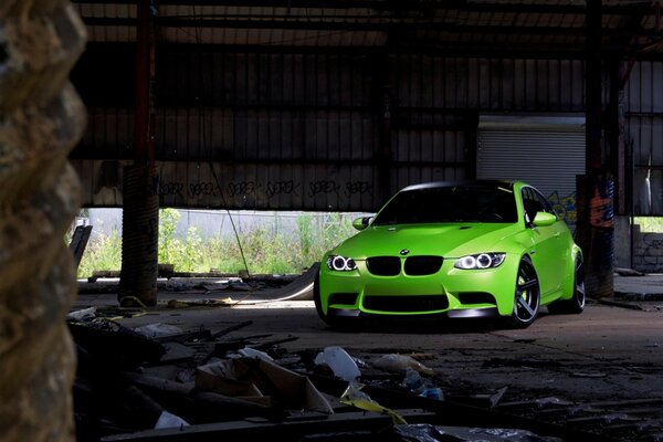 A green bmw car stands under a canopy