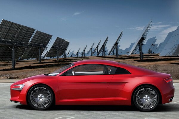 Audi red car sideways on the field with solar panels