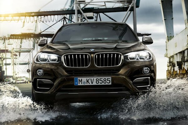 Il crossover nero BMW si precipita in una pozzanghera