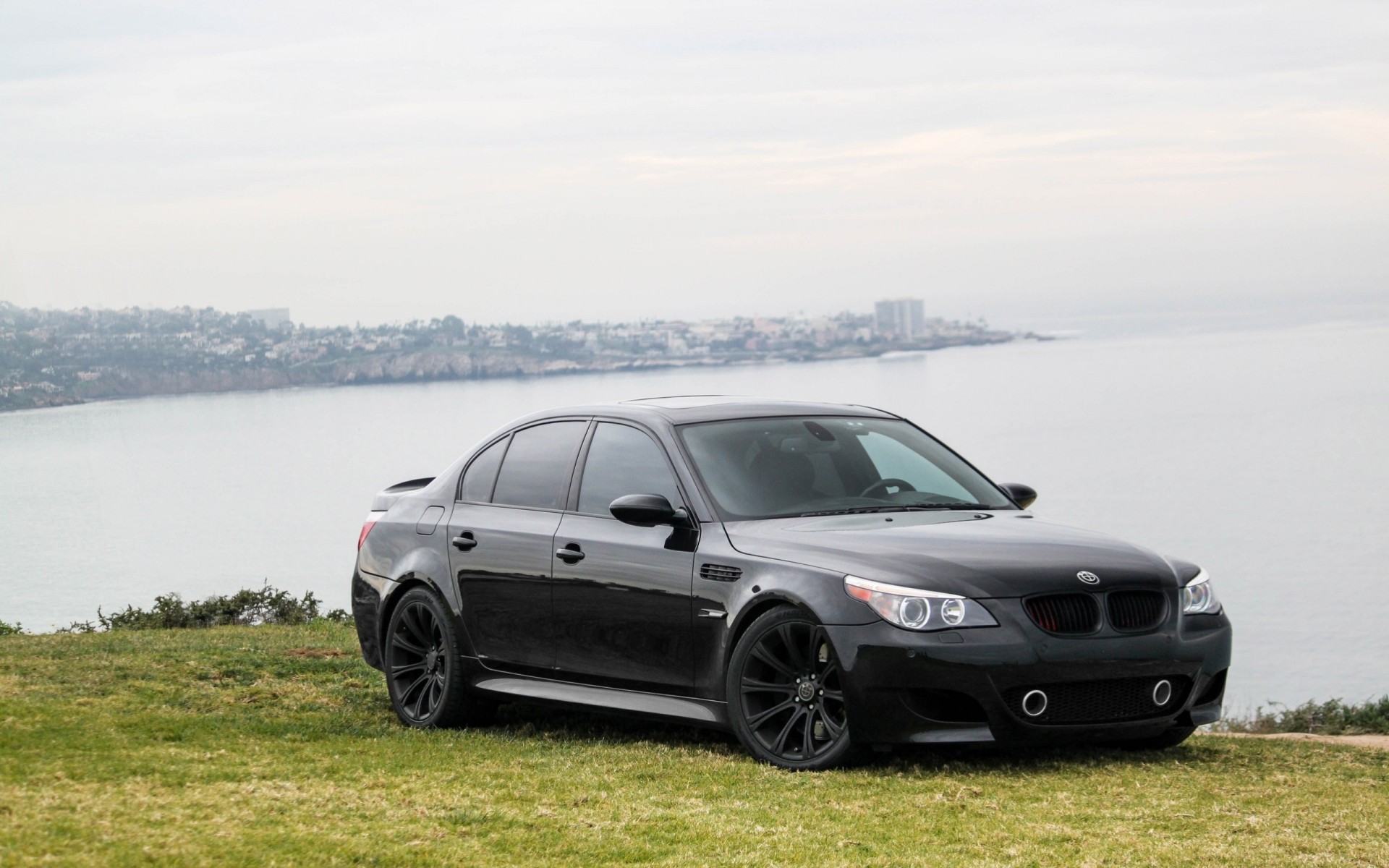 m5 sedán deportivo bmw negro cielo mar césped e60