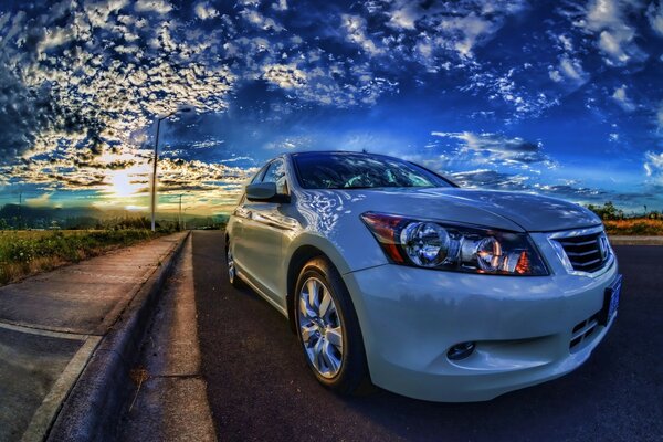 Coche blanco en la carretera bajo el cielo al atardecer