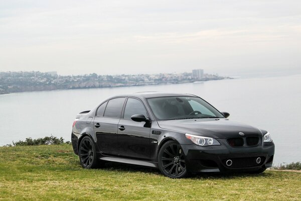 Sport sedan bwm m5 on the seashore stands on the lawn