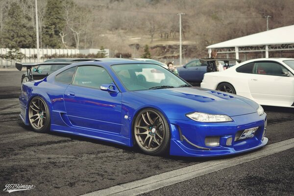 Blue nissan with a white car