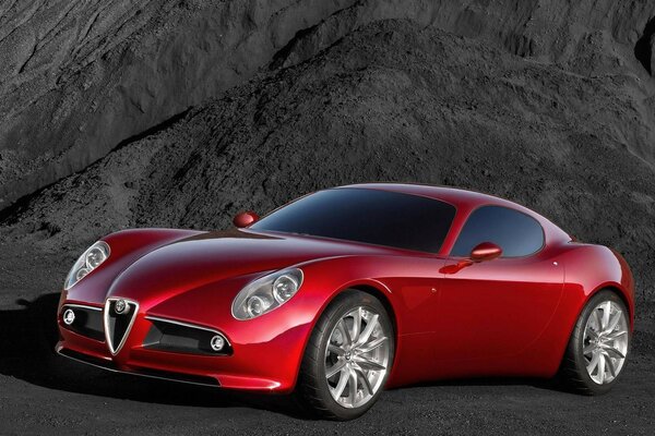 A red sleek car on a black rock background