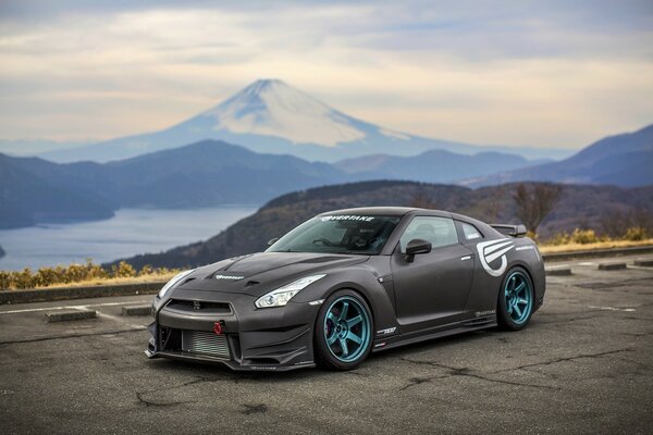 Voiture tuning noir sur fond de montagnes