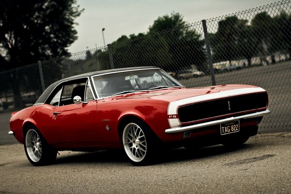 Camaro rojo en el fondo de la Cancha deportiva