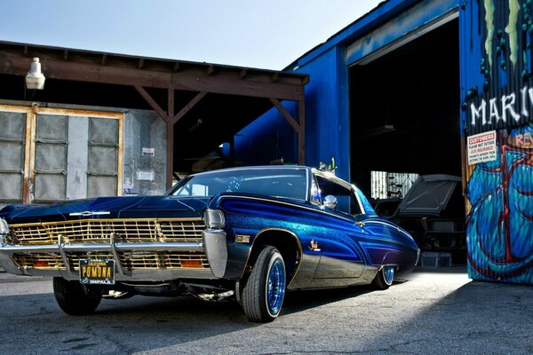 Auto Lowrider blu vicino al garage