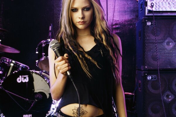 Avril Lavigne with a microphone on stage