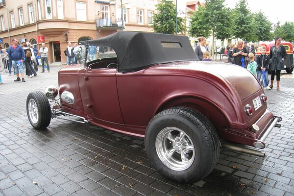 Vintage red car on a busy street