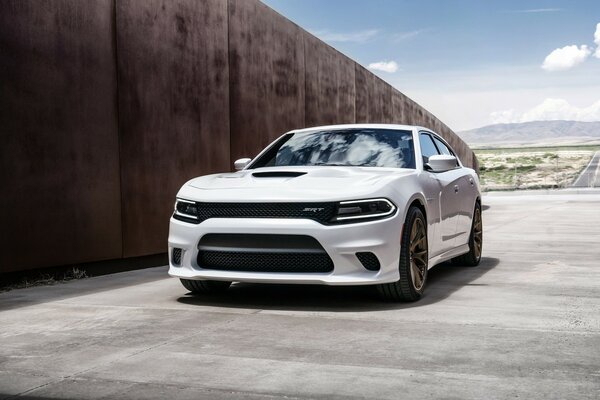 White 2015 hellcat sedan against a dark wall