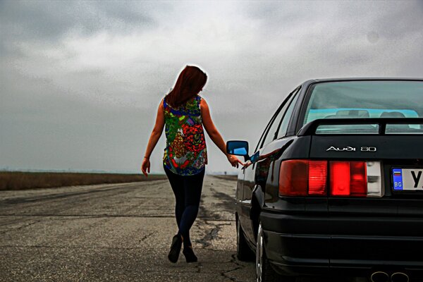 Fille sexy à côté de la voiture noire Audi