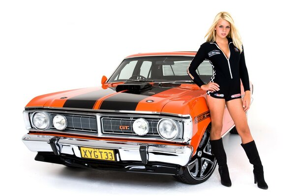 Leggy blonde next to an orange and black ford