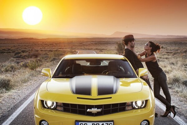 El camino que va más allá del horizonte y amarillo chevrolet corvette con una chica y un chico