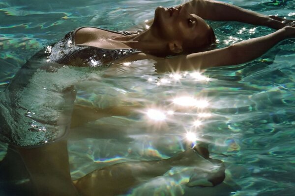 A girl in a swimsuit arched in the pool