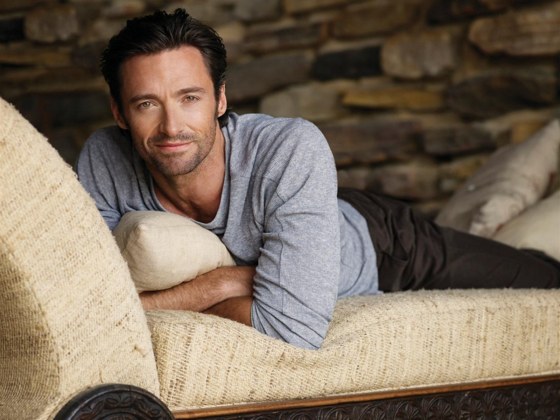 repos sur le canapé hugh jackman poils légers regard sourire acteur célébrité minet mal rasé yeux visage