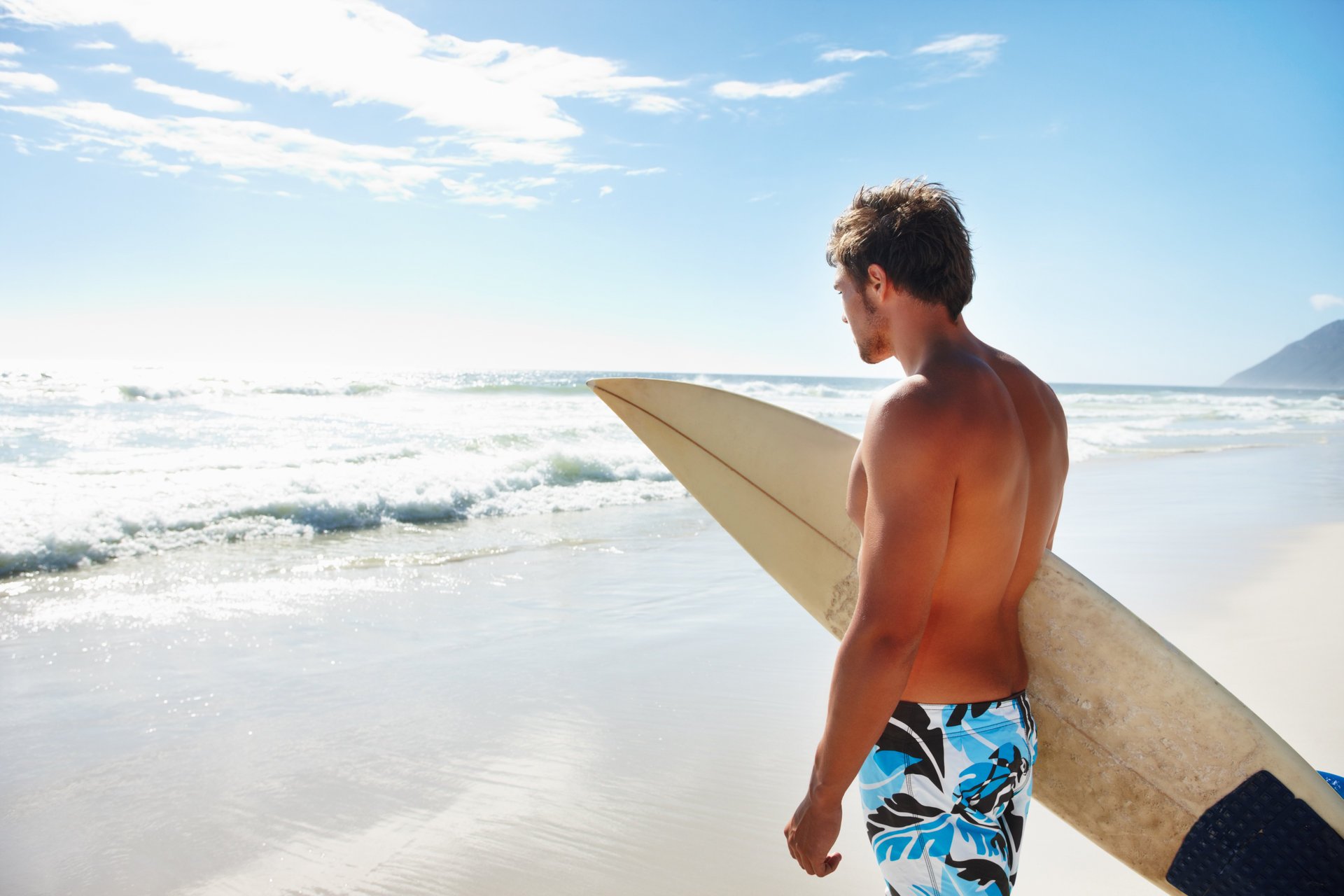 maschio sulla spiaggia bordo mare sport ragazzo surf onde spiaggia riva nuvole cielo