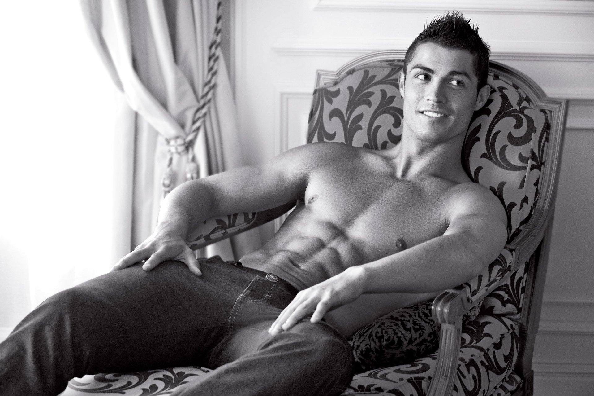 ronaldo chaise sculptée footballeur regard b-b minet beau gosse macho torse muscles corps sexy sourire regard de côté jeans chambre yeux visage noir et blanc