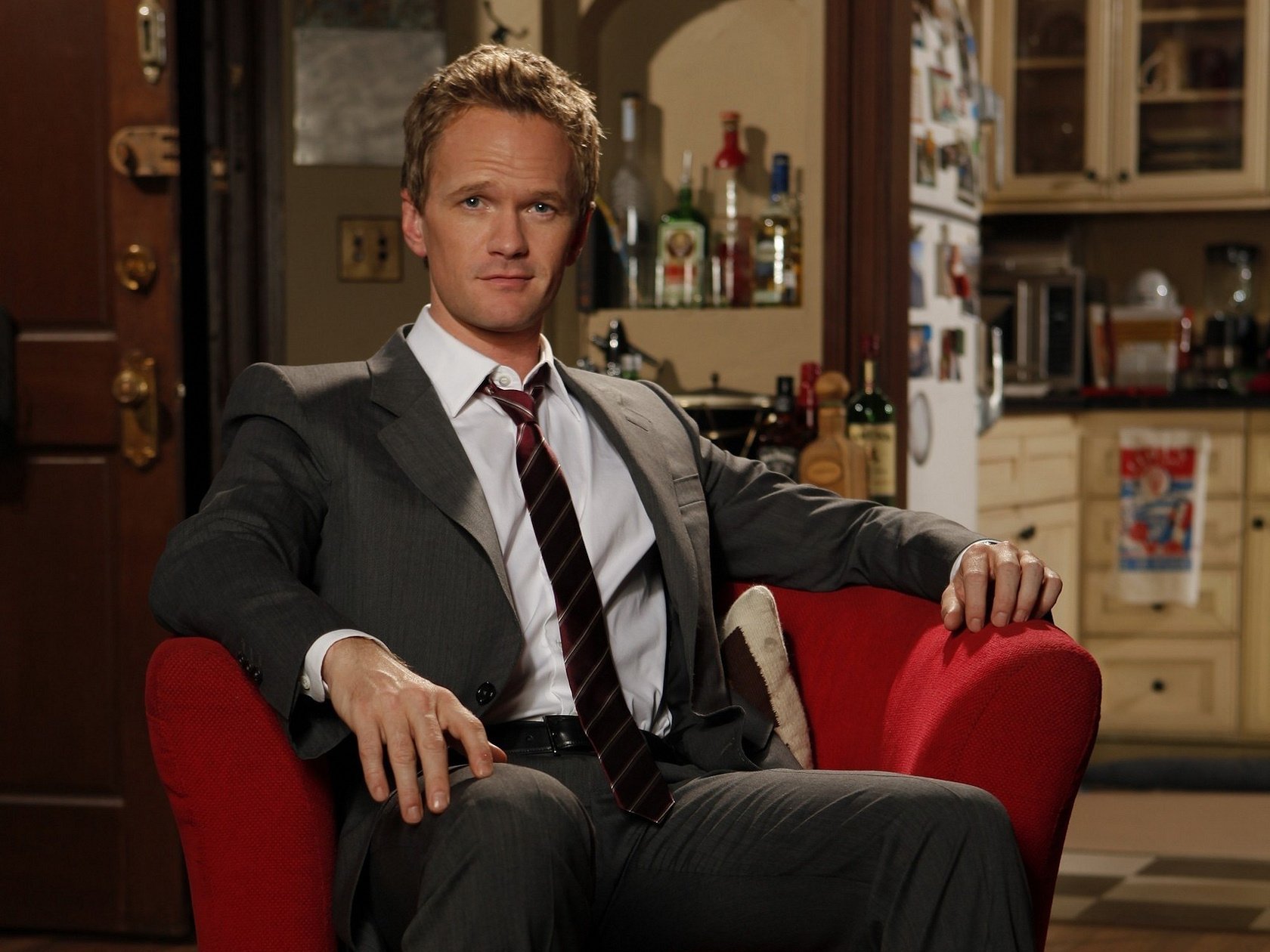 neil patrick harris vestito sedia rossa sguardo ritratto attore cravatta bottiglie alcol sorriso attore cinematografico occhi faccia film film