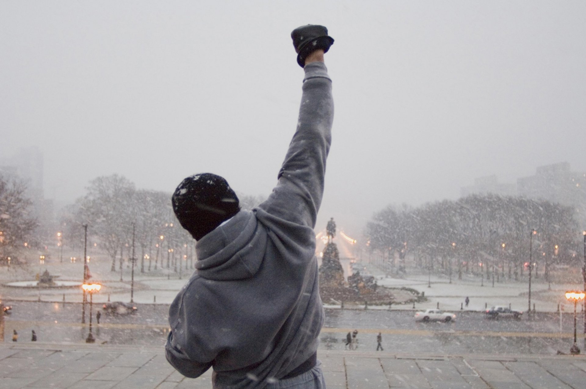 rocky inverno strada neve città uomini cinema schiena braccio monumento scultura piazza lanterne città ragazzo auto pedoni vento sera