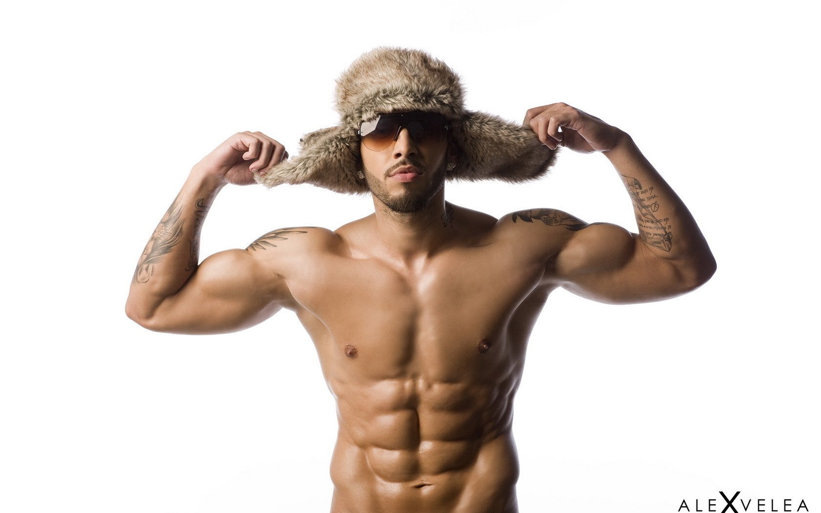 homme pompé chapeau de fourrure chapeau ushanka poils jock tatouage muscles torse lunettes mal rasé fond fond blanc visage