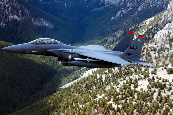 Avión de combate vuela sobre montañas nevadas