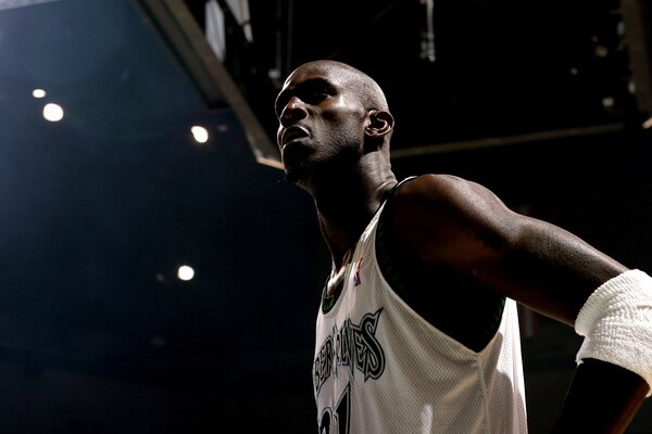 A black man in a T-shirt on a basketball field