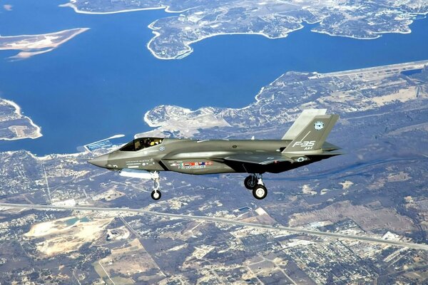 Un avión militar vuela sobre la ciudad. Plan de terreno