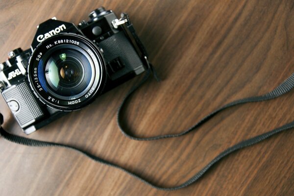 Black Canon camera on a wooden table