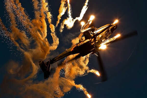 Hélicoptère apache encerclant la nuit dans le ciel en pleine lumière