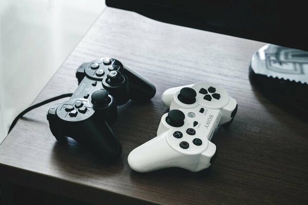 Deux gamepads noir et blanc sur la table