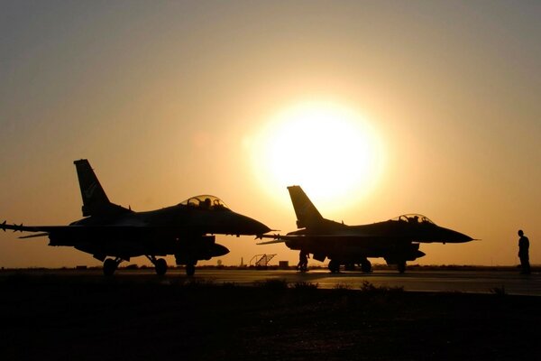 Avion militaire f-16 au coucher du soleil