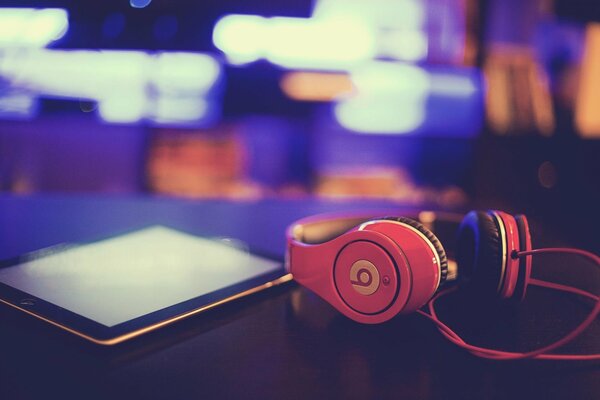 Headphones with a tablet lying on the table