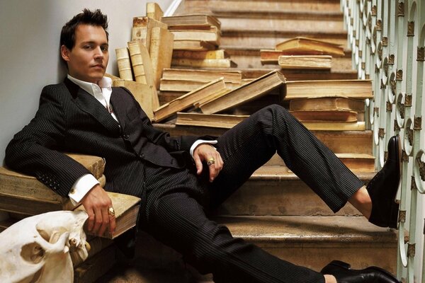 Johnny Depp en las escaleras entre libros dispersos