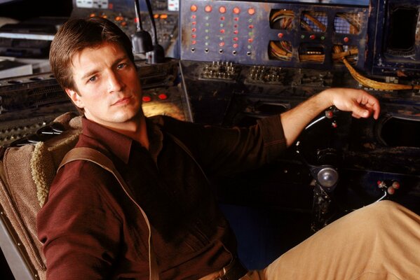 Guapo actor de la película los tíos. El actor Nathan Fillion en el control remoto