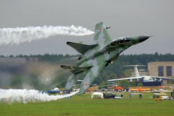 Ein graues Flugzeug führt eine Kunstflugfigur beim Start aus