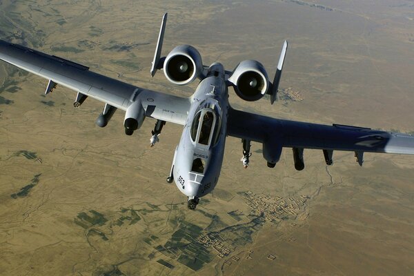 Un grande aereo militare vola sopra la terra