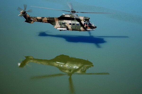 Helicóptero militar se cierne sobre el agua