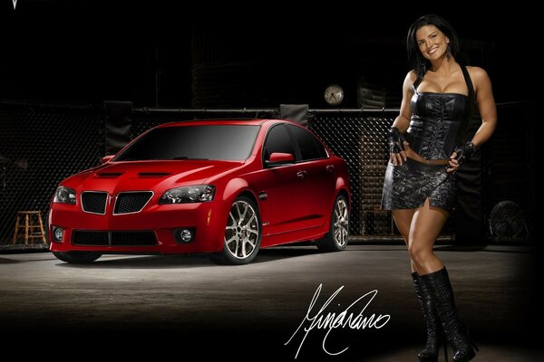 Chica con vestido negro en el fondo de un coche rojo