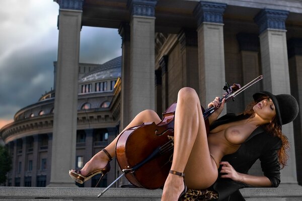 Ragazza nuda con strumento musicale tra le gambe