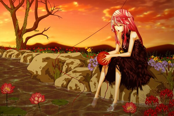 A painted girl in a dark dress with pink hair is sitting in a field on a stone