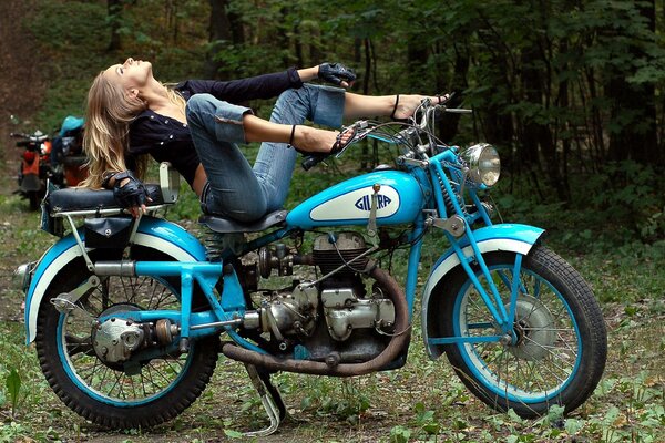 Moto classica blu e ragazza seduta su di esso