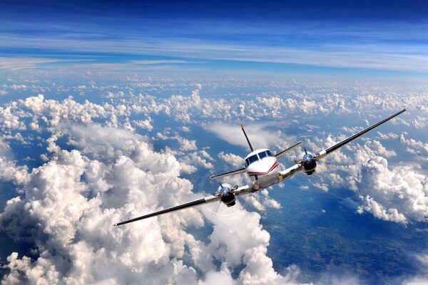 Aereo alto tra le nuvole sotto il cielo blu