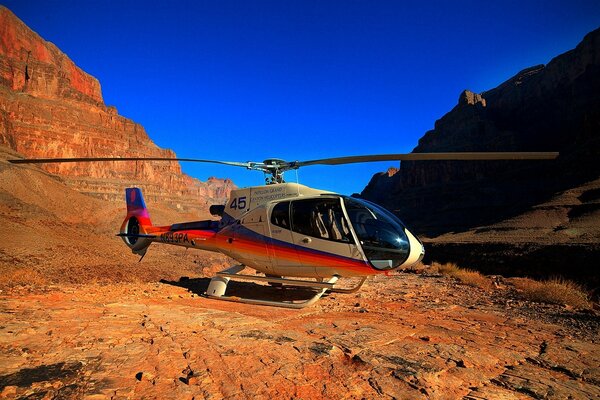 Hubschrauber auf dem Hintergrund der hohen Felsen des Grand Canyon