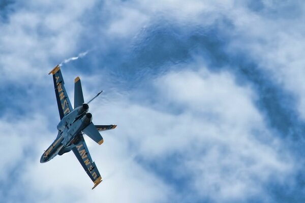 Aereo da caccia blu nel cielo con le nuvole