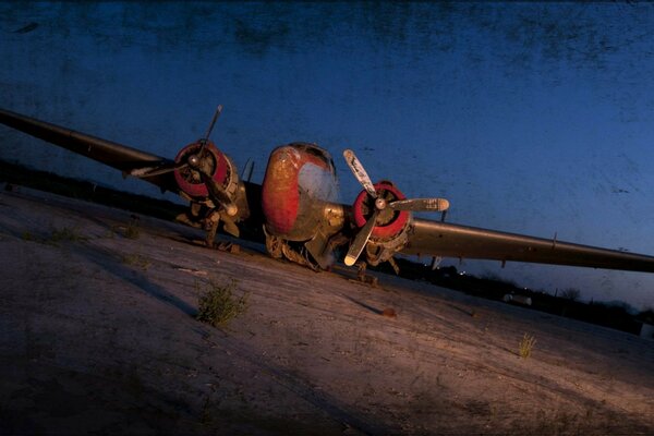 Vecchio aereo arrugginito sulla corsia aerea notturna