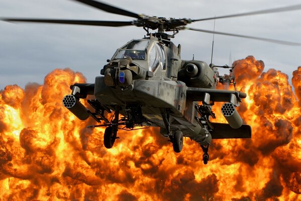 A military helicopter on the background of fire from an explosion