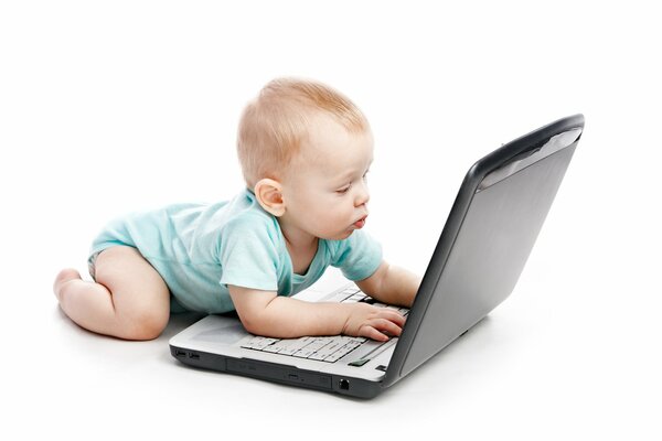 A small child carefully looks at the laptop monitor