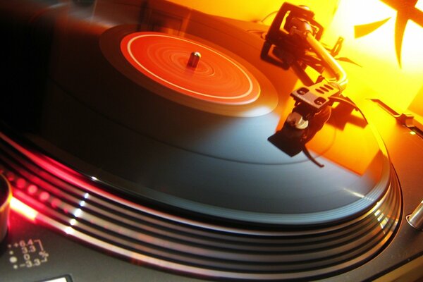 On the turntable is a vinyl record in orange light