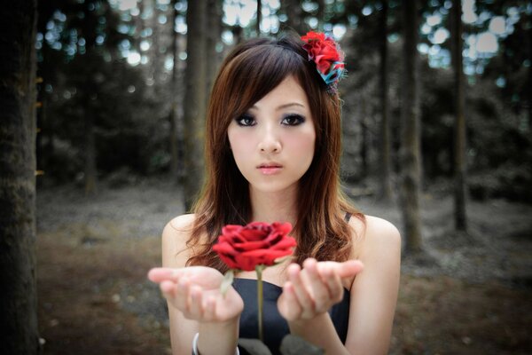 Asiatische Mädchen mit Rosen im Wald